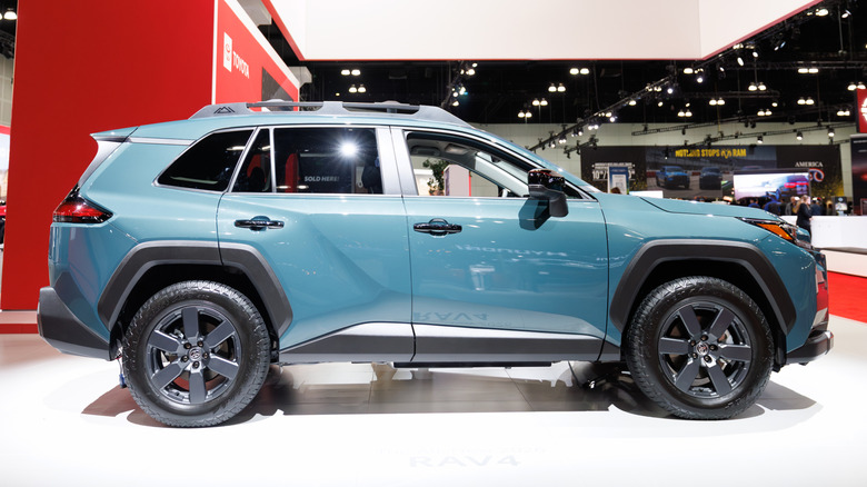 A side view of a teal 2026 RAV4 on display at a car show
