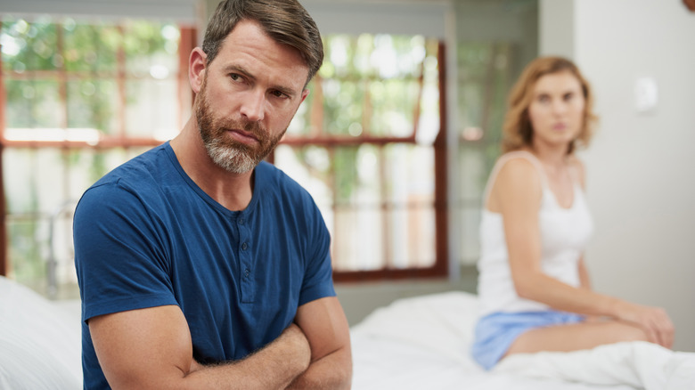 A man looking upset and away from woman next to him.