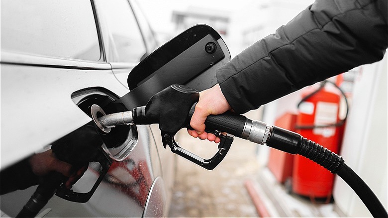Person refueling car at pump