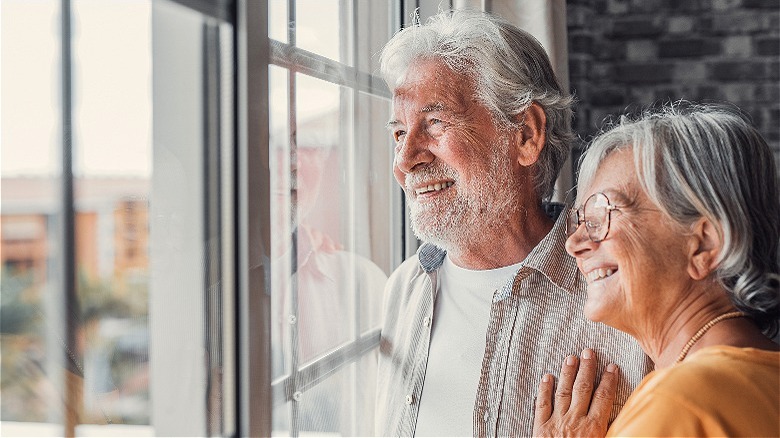 Boomer couple looking out window