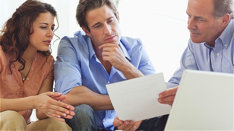 Person explaining document to couple