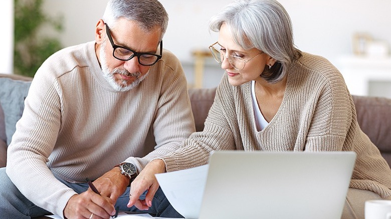 Senior couple working on paperwork at home