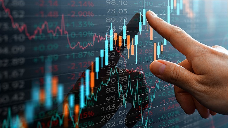 Finger pointing at candlestick chart