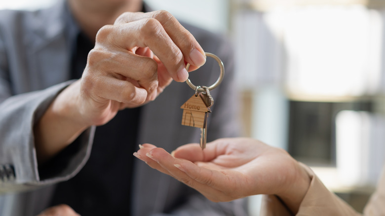 Person handing another person the keys to a house