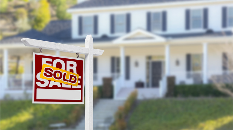 Sold sign in front of a large house