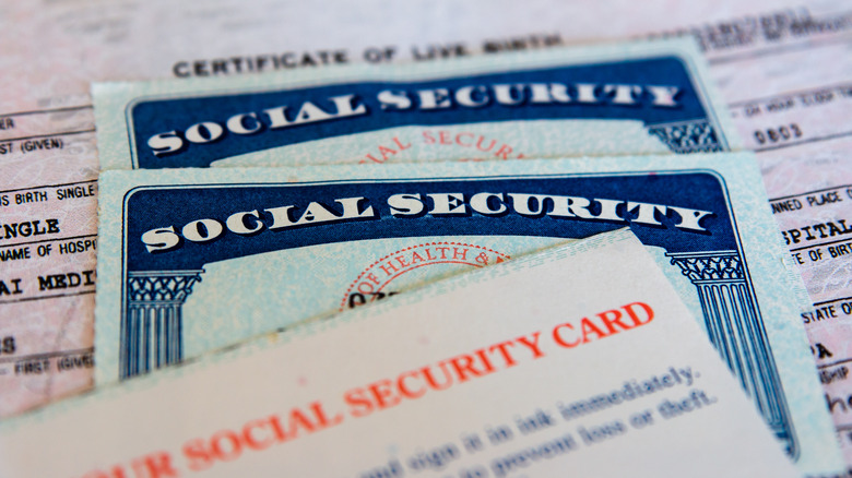 United States Social Security cards with birth certificate background.
