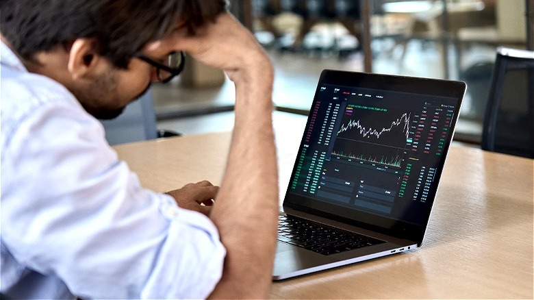 Person stressfully watching stock prices