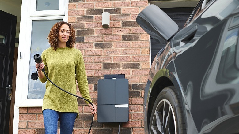 Person charging electric vehicle