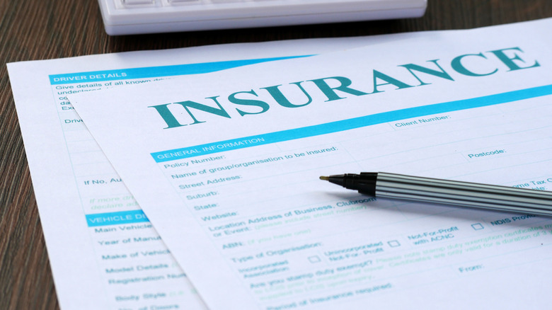 Incomplete insurance documents with pen resting on top