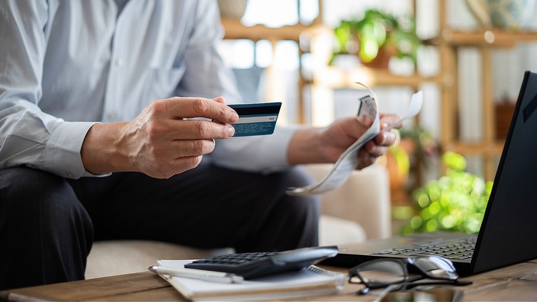 Person holding receipts, credit card
