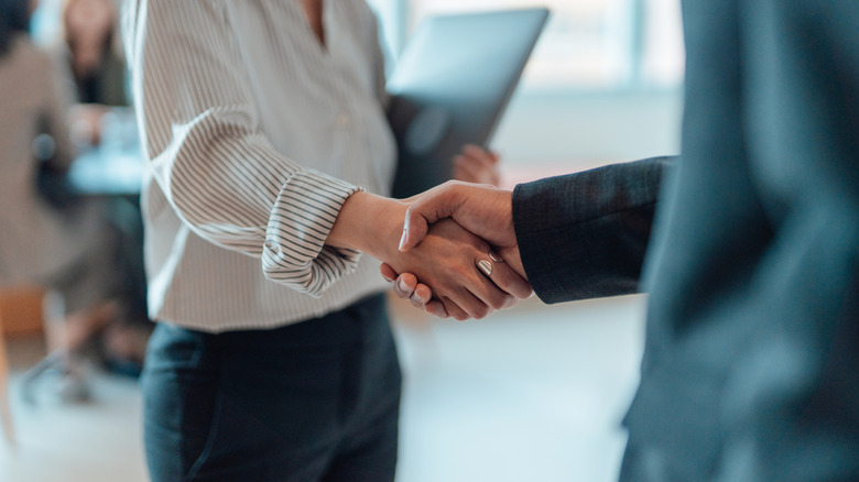 Cropped shot of business people standing in a modern office, shaking hands after having a successful meeting and reaching an agreement.