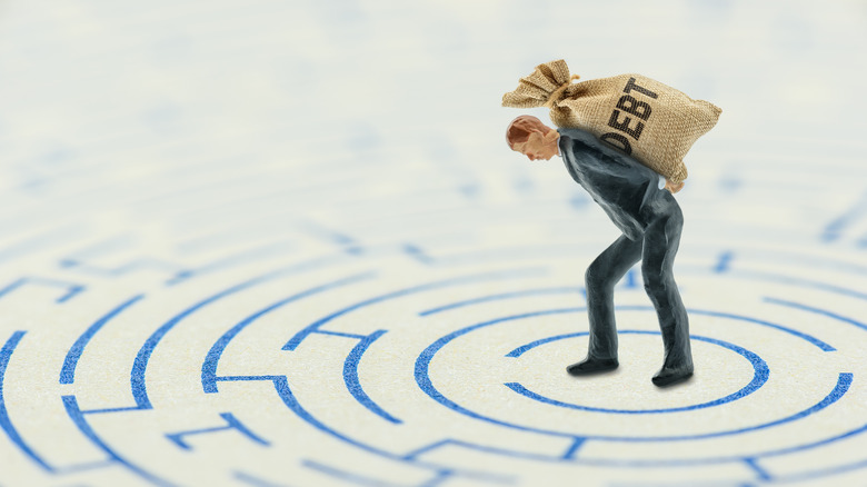 carrying debt bag in maze
