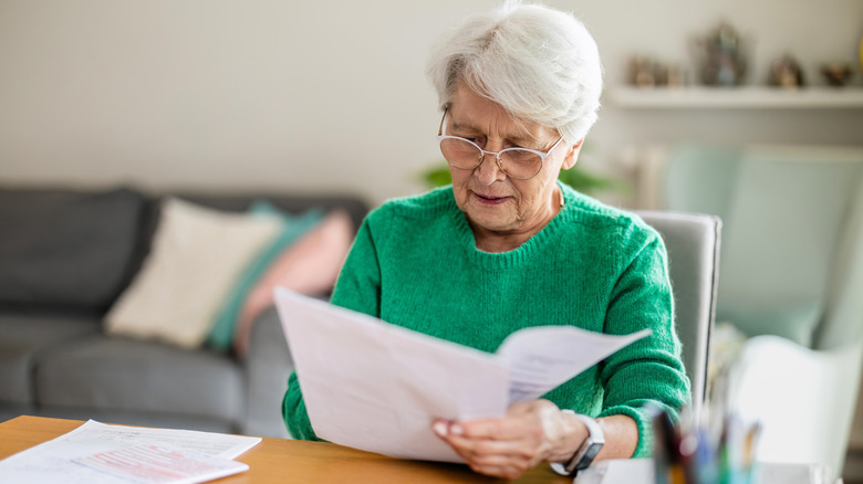 Elderly woman checking life insurance papers.