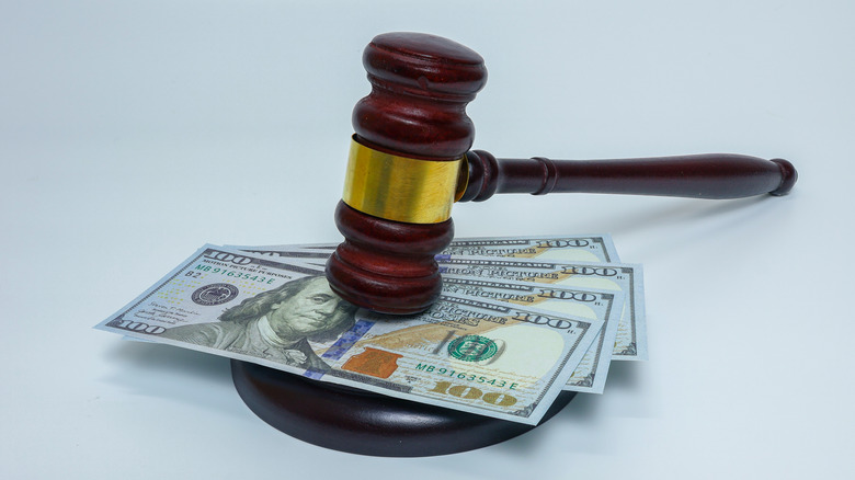 Judge gavel and money on white background representing fine.