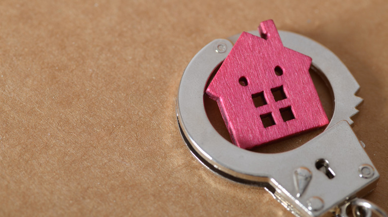 handcuff around a house figurine