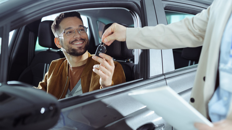 man taking keys from salesperson