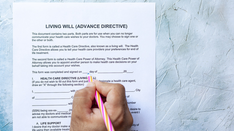 A hand signing a living will