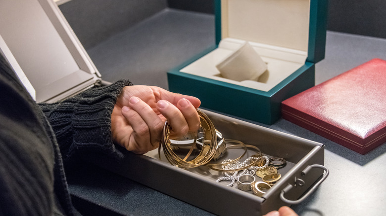 a woman holding gold jewelry