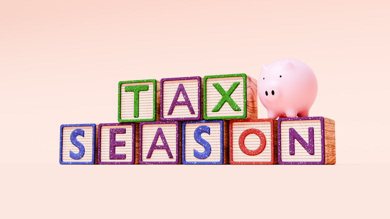 Toy blocks spelling out the words "Tax Season" with a piggy bank sitting on the 'N'.
