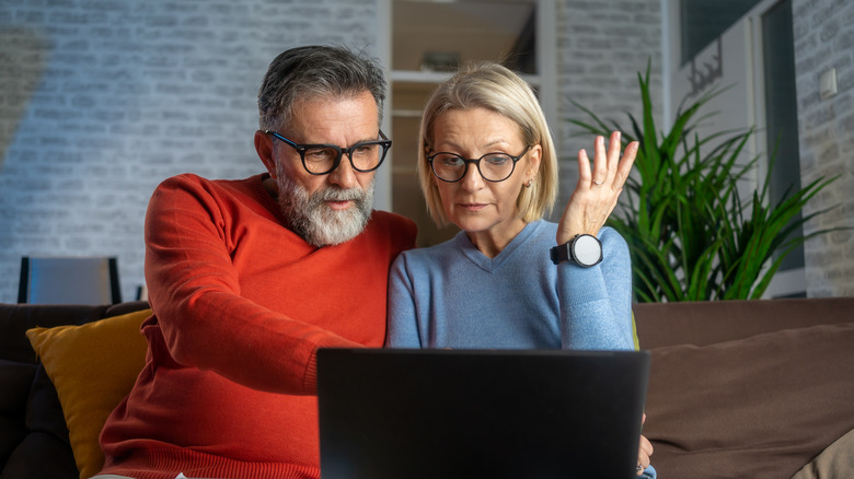 Mature couple looking at information on a laptop