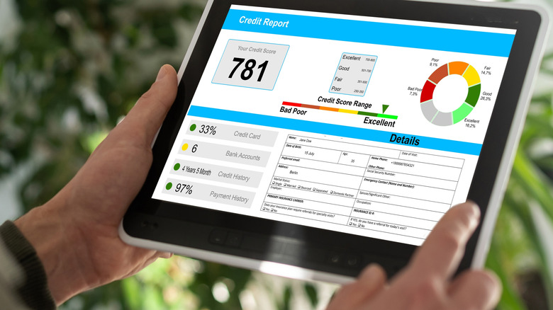 person holding a tablet with their credit report showing score of 781