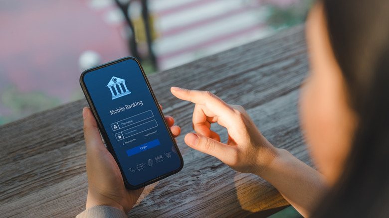 Woman logs into bank account using app on smartphone