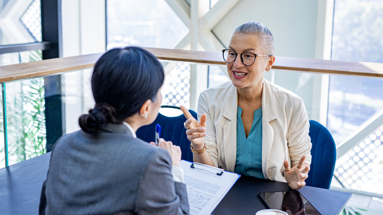 Two women in an office going over paperwork and discusssing financial strategy
