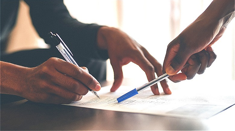 Person filling out financial paperwork