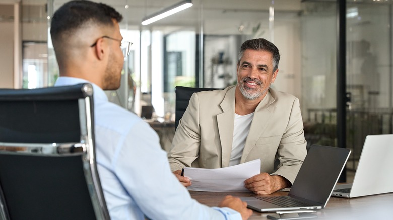 A financial advisor talking to a male client at a desk