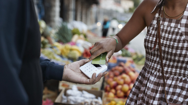 Person paying street vendor with card