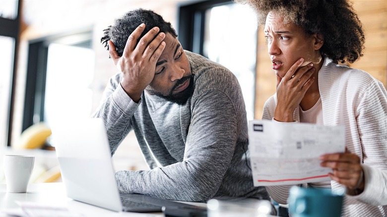 Couple looking worried over letter