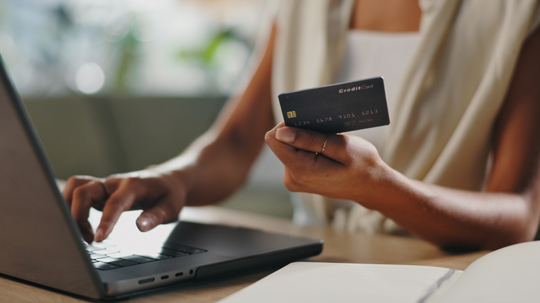 Person holding a credit card while making an online purchase