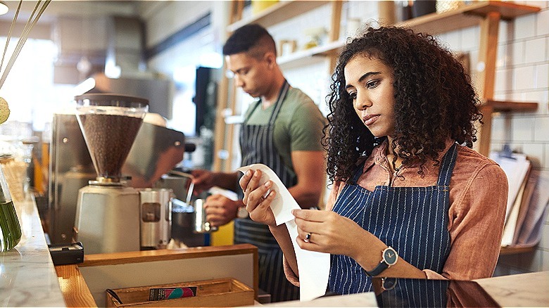 Barista looks over receipts