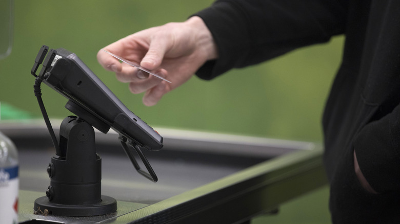 Person paying with credit card at pin pad