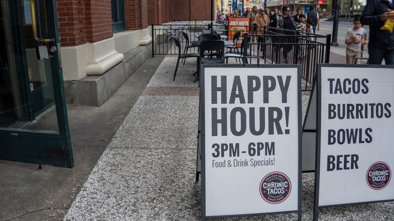 Sign outside of a taco shop advertising happy hour