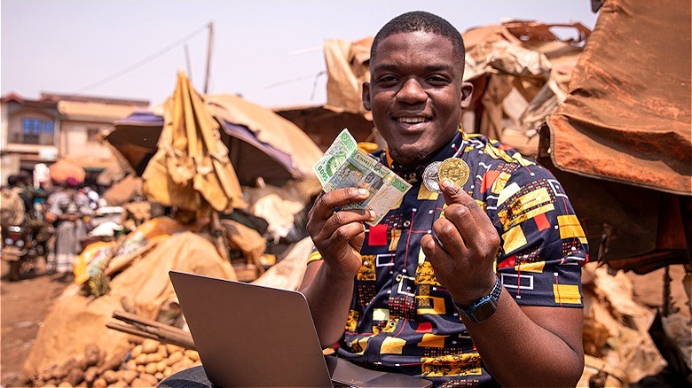 Person outside holding bitcoin/bills