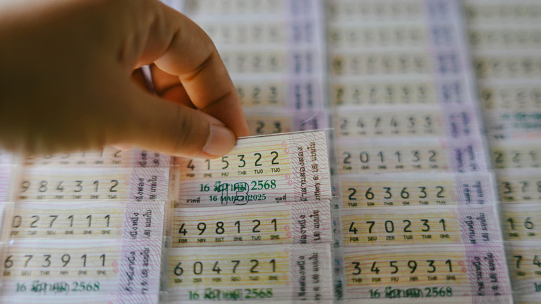 lottery tickets and a hand taking one