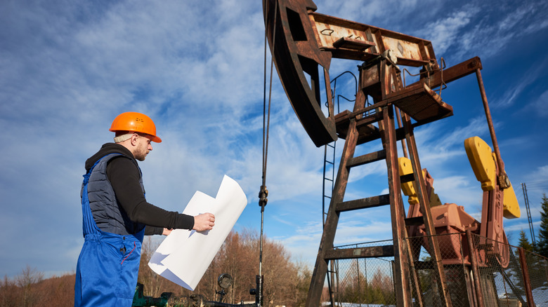 A man beside an oil pump