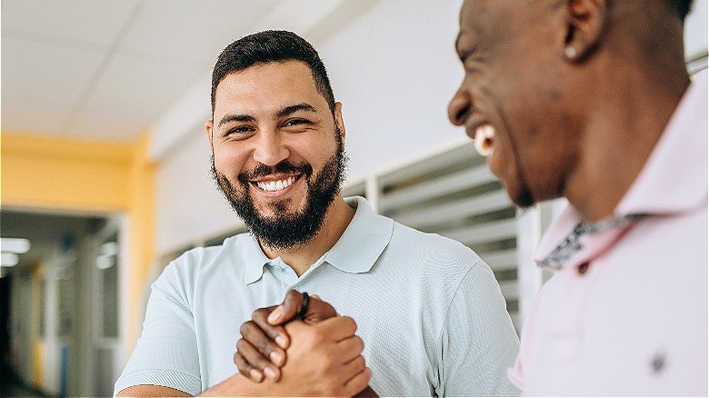 Two people smiling, shaking hands