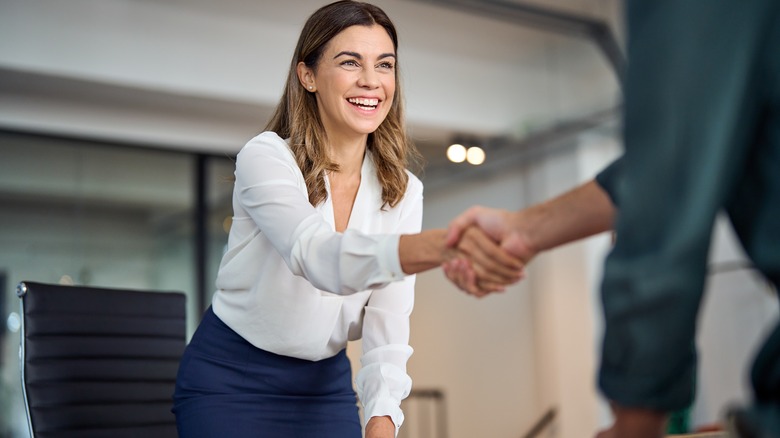 A smiling woman shaking hands