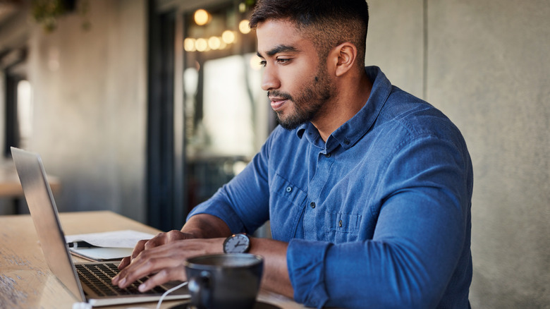 A man typing on his laptop