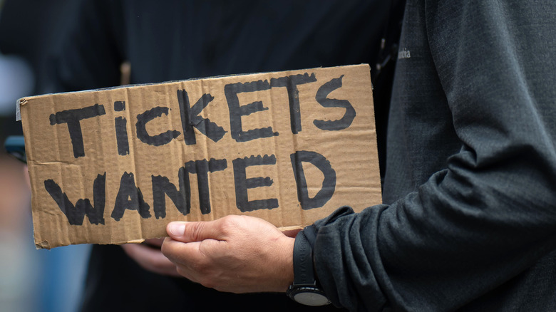 person holding tickets wanted sign