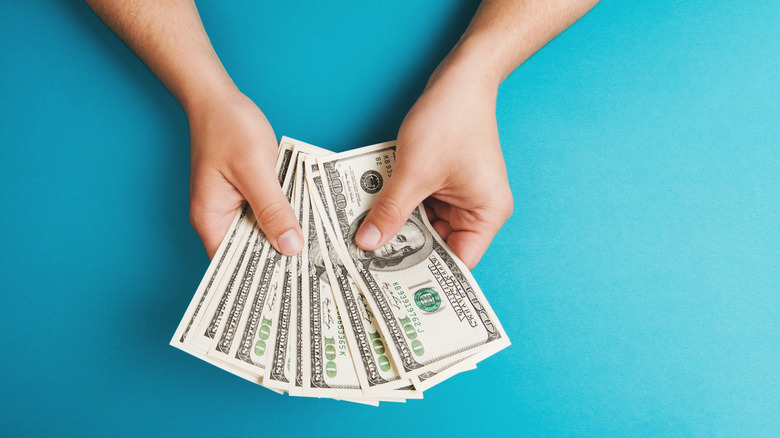 hands holding cash fanned out