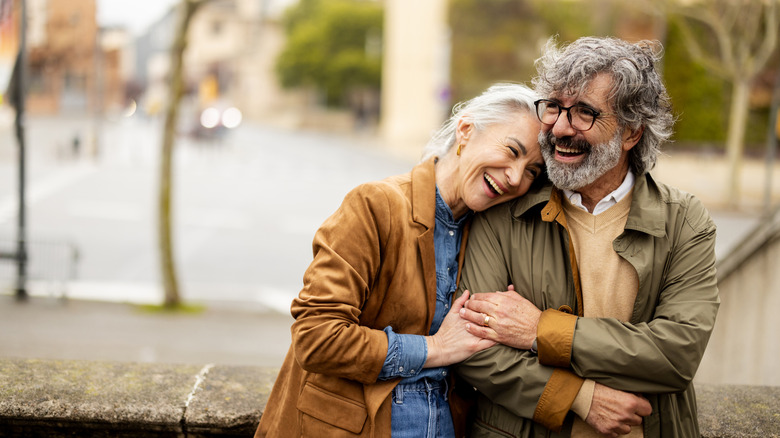 retired people smiling and hugging