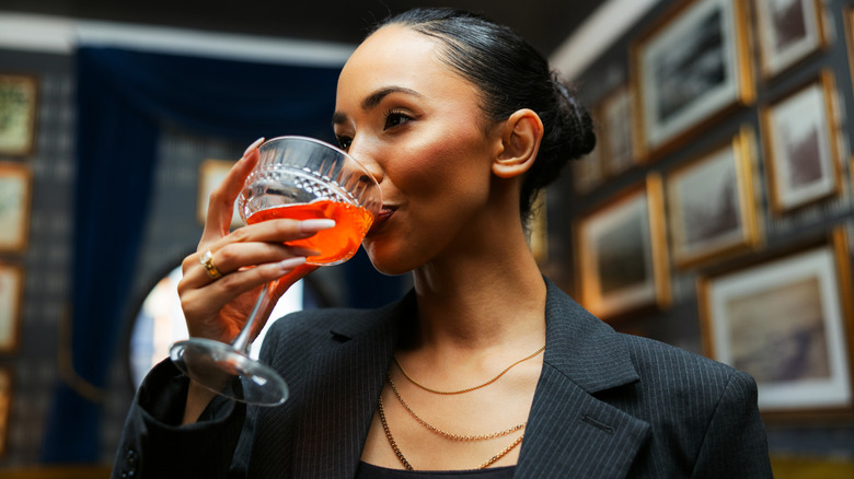 A well dressed woman sipping a Kentucky bourbon cocktail in a luxurious lounge