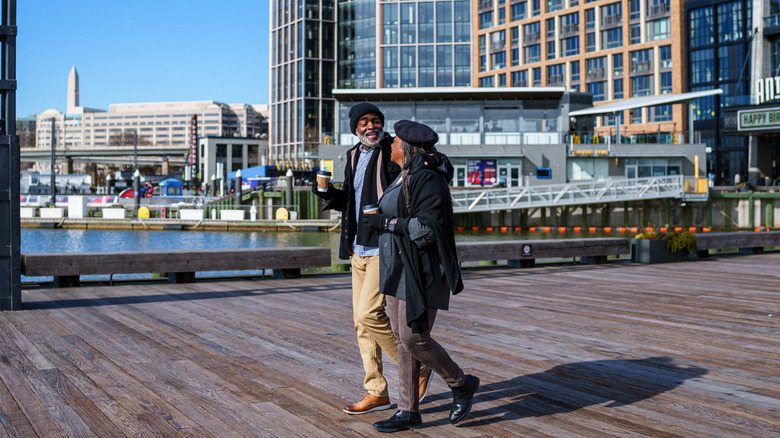 A mature couple walking along the waterfront boardwalk in Washington.