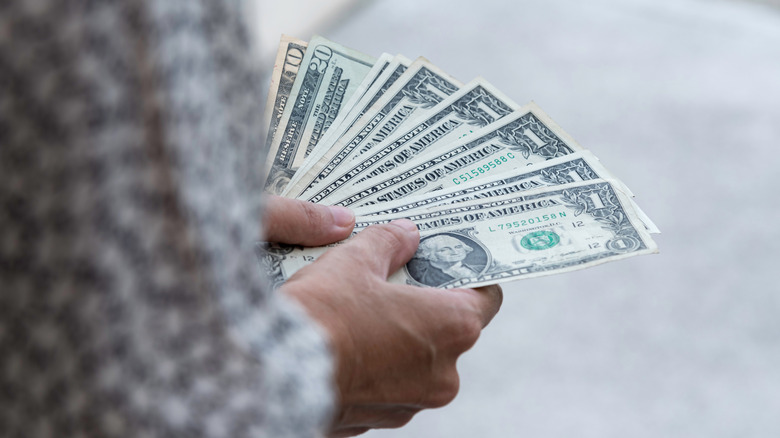 Hands holding an assortment of cash