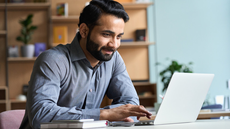 businessman in his 30's looking at laptop