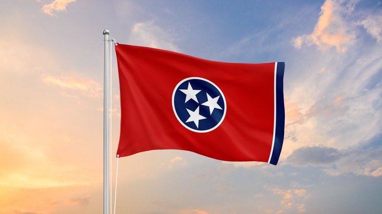 Tennessee flag waving against a sunset sky.