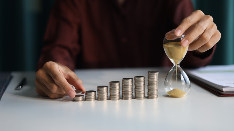 Rising stack of coins and an hourglass symbolizing long-term growth